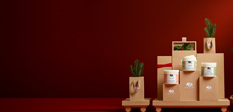 Origins carton gift boxes and shopping bags and Ginger body creams laid on a carton train