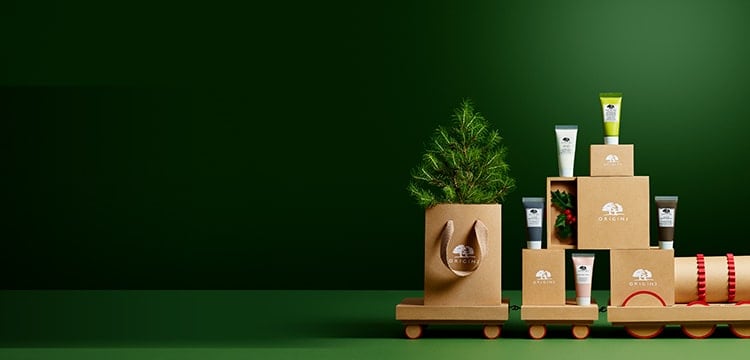 Origins masks set and sustainable carton gift boxes are sitting on a carton train. 